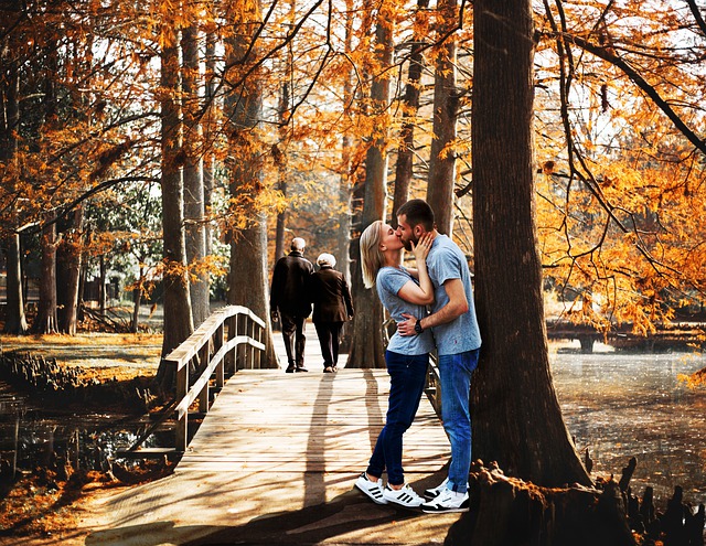 žena a muž se líbají v podzimním parku