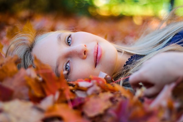 žena přemýšlí v listí nad podzimním rande